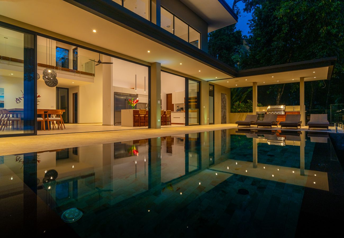 Infinity pool reflecting the villa lights after dark