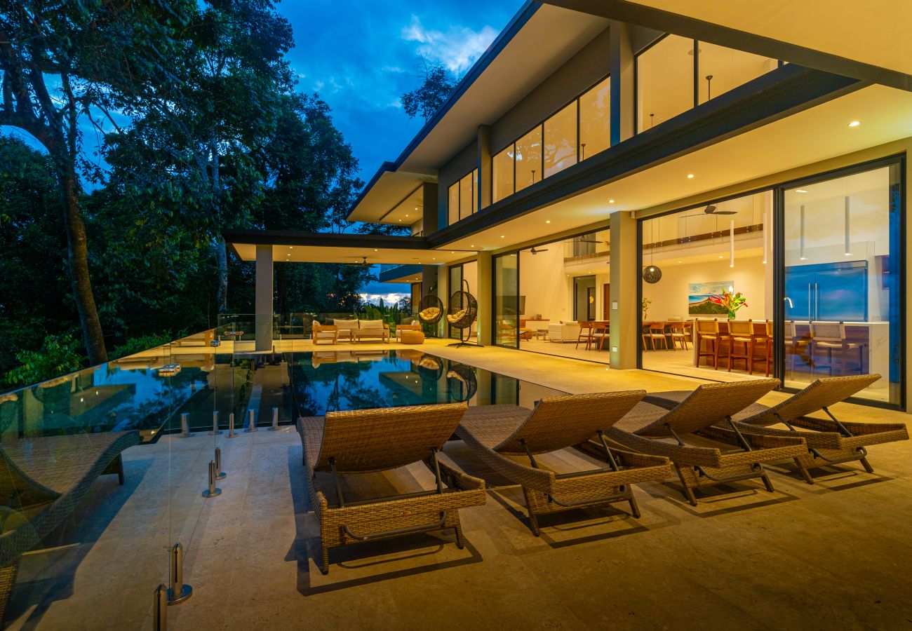 Outdoor seating area lit at night beside the pool