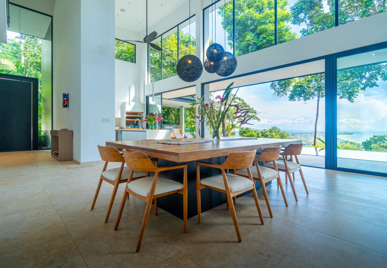 Dining table near floor-to-ceiling windows with ocean views