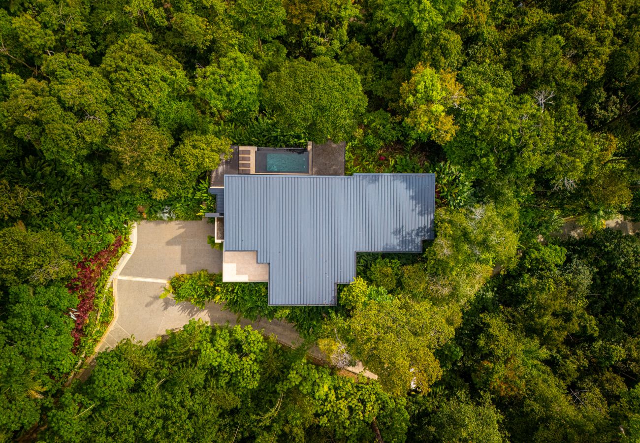 Aerial view of the villa roof surrounded by rainforest canopy
